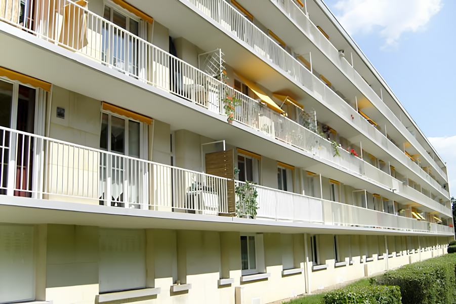 Résidence collective avec volets blancs et balcons restaurés par Restor'A9
